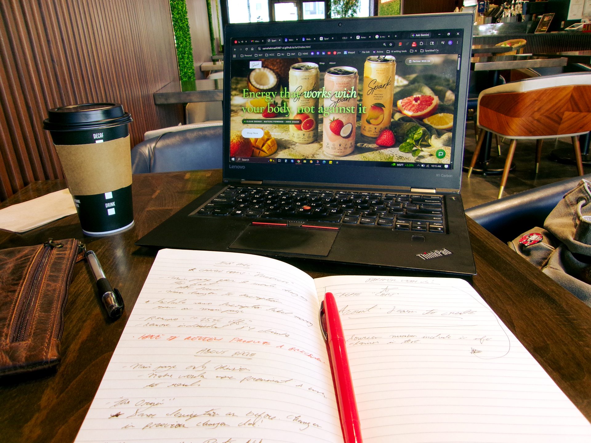 Laptop showing Sparkleaf website with notebook and coffee