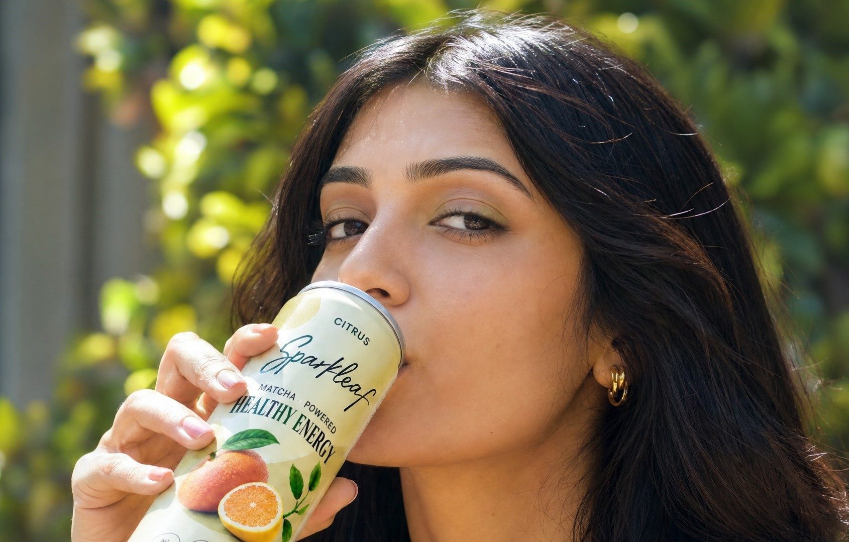 Woman drinking Sparkleaf Citrus outdoors